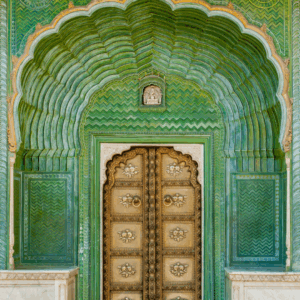 Ornate golden door framed by intricate green archway at the City Palace in Jaipur, India